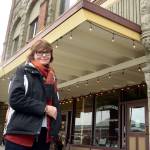 Mari Mullen, director of the Port Townsend Main Street Program, stands in front of the historic Kuhn Building, which was a recipient of a loan in order to fix all the windows on the building&rsquo;s second story. (Cydney McFarland/Peninsula Daily News)