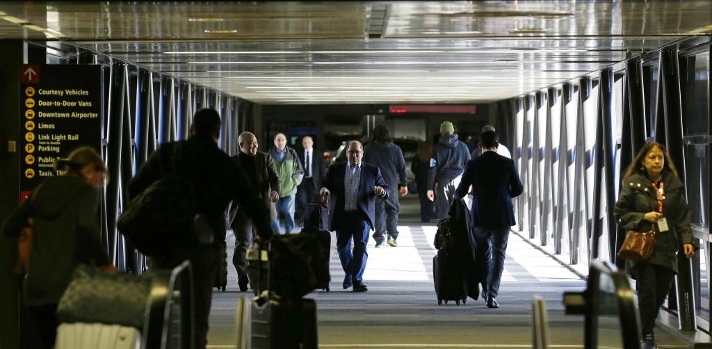 Pedestrians walk through a skybridge at Seattle-Tacoma International Airport near the international arrivals area Tuesday. (Ted S. Warren/The Associated Press)