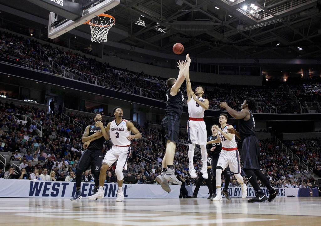 Gonzaga guard Nigel Williams-Goss, center, right, shoots over Xavier&rsquo;s Sean O&rsquo;Mara, center left, during the first half of an NCAA Tournament college basketball regional final game Saturday, March 25, 2017, in San Jose, Calif. (AP Photo/Tony Avelar)