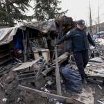 In this photo taken March 6, Seattle Police Officer Tawnia Pfaff makes her way past debris after talking with a homeless man living under tarps behind her in Seattle. (Elaine Thompson/The Associated Press)