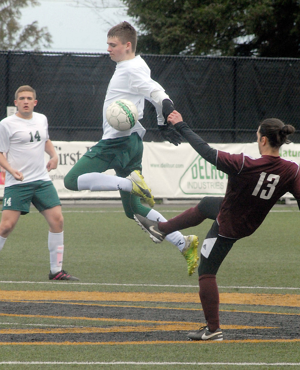 Keith Thorpe/Peninsula Daily News Port Angeles&rsquo; Michael Scott, center, leaps high to block a pass by Ketchikan&rsquo;s Giovaniu Covelli as Scott&rsquo;s teammate, Karsten Hertzog, left, looks on during Saturday&rsquo;s nonleague matchup at Peninsula College in Port Angeles.