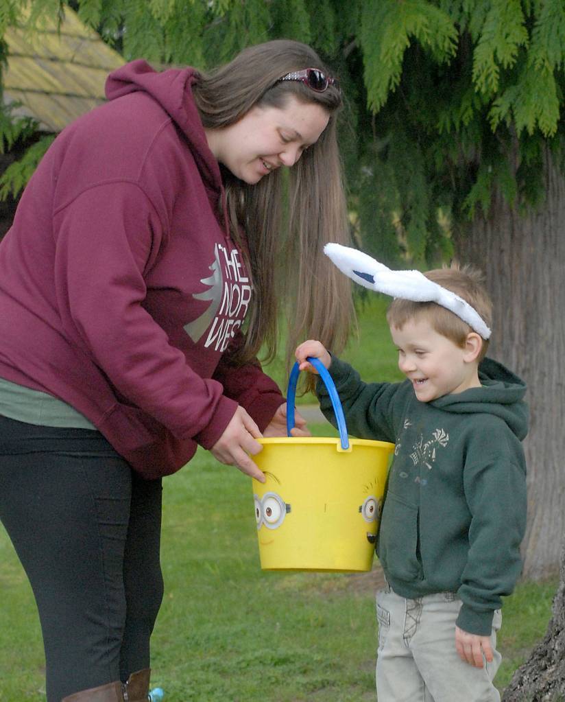 Thomas Dallgardno, 3, shows off his bucket of eggs to his mother, Whitney Dalgardno of Port Angeles, during Saturday&rsquo;s KONP Easter egg hunt at the Clallam County Fairgrounds in Port Angeles. (Keith Thorpe/Peninsula Daily News)