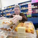 Mary Patterson, who recently received the Governor&rsquo;s Volunteer Service Award, stocks food at the Port Angeles Food Bank on Monday. (Jesse Major/Peninsula Daily News)