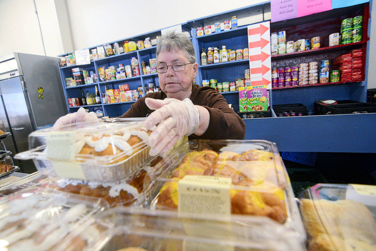 Mary Patterson, who recently received the Governor&rsquo;s Volunteer Service Award, stocks food at the Port Angeles Food Bank on Monday. (Jesse Major/Peninsula Daily News)