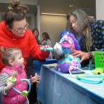Two-year-old Ryliegh Baker looks on as her aunt, Nicole Baker of Port Angeles, left, and pediatrician Grace Yelland give a medical examination to the youngster&rsquo;s stuffed animal as a grand opening activity Saturday for a new medical office building constructed by Olympic Medical Center in Port Angeles. (Keith Thorpe/Peninsula Daily News)