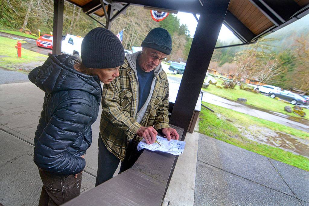 Dani Campbell and Randy Gray look over a map over the area surrounding the Sol Duc River on Wednesday as they prepare to look for Gray&rsquo;s son, Jacob Gray, an avid outdoorsman who disappeared in Olympic National Park on April 6. (Jesse Major/Peninsula Daily News)