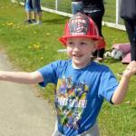 Kiedis Wong of Quilcene waves at the Quilcene Fire Rescue firetrucks that came out for the Brinnon Loyalty Day parade Friday. (Cydney McFarland/Peninsula Daily News)