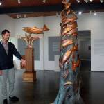 Exhibit curator Randy Powell discusses the sculpture &ldquo;Our Elwha&rdquo; by copper artist Clark Mundy as another Mundy sculpture, &ldquo;Four Winds,&rdquo; stands in the background in the main room of the Port Angeles Fine Arts Center. (Keith Thorpe/Peninsula Daily News)