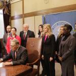 Gov. Jay Inslee signs a measure Tuesday in Olympia to make it easier for victims of sex trafficking to vacate prostitution convictions. Current law doesn&rsquo;t allow victims to vacate prostitution convictions if other crimes exist on their criminal record. (Rachel La Corte/The Associated Press)