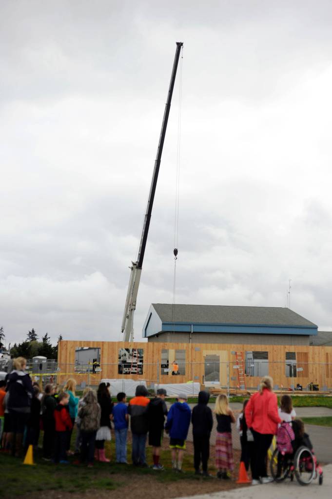 Students at Greywolf Elementary School look on as construction begins in full on two modular buildings at their Carlsborg school Monday. (Michael Dashiell/Olympic Peninsula News Group)