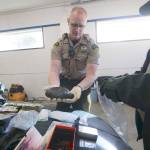 Clallam County Sheriff&rsquo;s Deputy Paul Federline holds what he estimated to be about two pounds of heroin while searching the car of someone who was reportedly driving recklessly on U.S. Highway 101 in Port Angeles on Sunday. (Jesse Major/Peninsula Daily News)