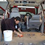 Employees of Skunkworks Auto Detailing & Body Repair Jesse Bailey, left, and Chris Babcock, right, volunteer to detail a donated van that will go toward Olympic Community Actions Programs&rsquo; senior nutrition program. (Erin Hawkins/Olympic Peninsula News Group)