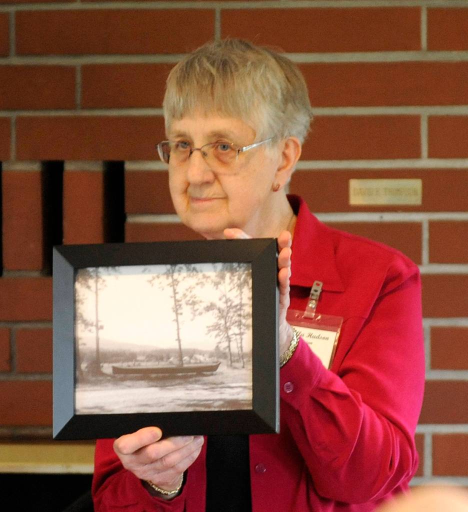 Priscilla Hudson, Sequim Prairie Garden Club member, shows a vintage photo of &ldquo;The Viola,&rdquo; a canoe that spent decades at Pioneer Memorial Park. The canoe was transported to Forks on April 8. (Michael Dashiell/Olympic Peninsula News Group)