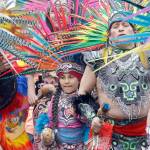Members of Ce Atl, an Aztec-inspired spiritual and cultural preservation group, dance near the front of a march for worker and immigrant rights at a May Day event Monday in Seattle. (Elaine Thompson/The Associated Press)