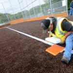 Lower Elwha Klallam facilities maintenance worker Mitch Boyd sets third base at the tribe&rsquo;s new athletic facility, the Billy Whiteshoes Memorial Park. The park is expected to be finished within the next two weeks. (Jesse Major/Peninsula Daily News)