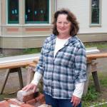 Cleone Telling, project leader of the restoration of the historic Worthington mansion in Quilcene, shows off the 120-year-old bricks salvaged from the cook stove in the mansion. Telling is the project leader, and these bricks will be auctioned off during a fundraiser for the museum. (Steve Mullensky/for Peninsula Daily News)
