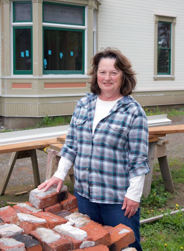 Cleone Telling, project leader of the restoration of the historic Worthington mansion in Quilcene, shows off the 120-year-old bricks salvaged from the cook stove in the mansion. Telling is the project leader, and these bricks will be auctioned off during a fundraiser for the museum. (Steve Mullensky/for Peninsula Daily News)
