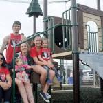 Perched on playground equipment at the Tod Horton On Deck Playground are, from left, seated, De Ann Horton; her daughter Hailey Daniels holding her youngest daughter, Mallie; and Kray Horton, holding Kinzie Daniels. Dustin Daniels, Hailey&rsquo;s husband, is standing in back. Not pictured is De Ann&rsquo;s oldest daughter, Whitney. (Lonnie Archibald/for Peninsula Daily News)
