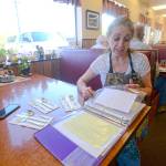 Roxanne Olsen, who owns the Blackberry Cafe in Joyce, looks through letters from people who have donated to &ldquo;Andy&rsquo;s Fund.&rdquo; (Jesse Major/Peninsula Daily News)