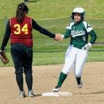 Keith Thorpe/Peninsula Daily News Port Angeles&rsquo; Kylee Reid, right, rounds second base is congratulated by Kingston&rsquo;s Lucy Schaeffer after Reid homered in the first inning during Wednesday&rsquo;s game at the Dry Creek athletic fields in Port Angeles.