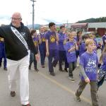 Sequim High School band director Vern Fosket, left, the grand marshal for the Irrigation Festival Grand Parade, marches with a kazoo band of Sequim school students. (Keith Thorpe/Peninsula Daily News)