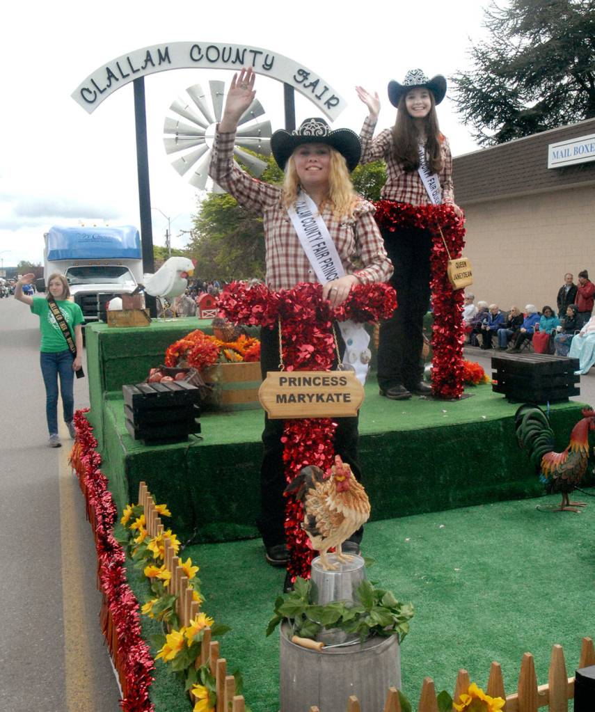 Clallam County Fair Princess Marykate Napiontek, left, and Queen Janeydean O&rsquo;Connor wave to Irrigation Festival Grand Parade spectators Saturday. (Keith Thorpe/Peninsula Daily News)