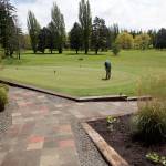 Steve Mullensky/for Peninsula Daily News PGA Golf Professional, Jeff Kent, practices putting on the green after new tiled walkways and landscaping work was recently finished. Additional landscaping will be installed at a later date.