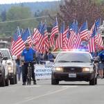 Sequim police followed by a contingent of flag carriers lead Saturday&rsquo;s Irrigation Festival Grand Parade in Sequim. (Keith Thorpe/Peninsula Daily News)