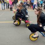 Rhododendron Festival royalty &mdash; from foreground, Princess Sarah Smith, Princess Taylor Tracer and Queen Lauren Montgomery &mdash; compete in the annual tricycle race, just one in a week full of events in Port Townsend. (Cydney McFarland/Peninsula Daily News)