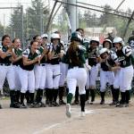 Lonnie Archibald/for Peninsula Daily News Port Angeles players mob Lauren Lunt at home plate after Lunt hit a grand slam in the first inning of the Roughriders&rsquo; 16-0 win Saturday over Orting. The victory sent the Riders to the West Central District 3 championship game.