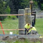 Justin Danbrosio, left, and Larry McCullough of Pinedale, Wyo.-based Wind River Stone Scapes install pieces Thursday for what will become a new entrance sign to Olympic National Park on the lawn in front of the park&rsquo;s Port Angeles visitor center. (Keith Thorpe/Peninsula Daily News)