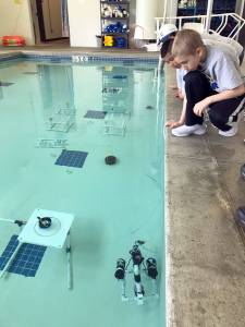 Students peer into the water at the Forks Athletic and Aquatic Center&rsquo;s pool at a remote-operated vehicle during the MATE ROV competition. (Olympic Coast National Marine Sanctuary)
