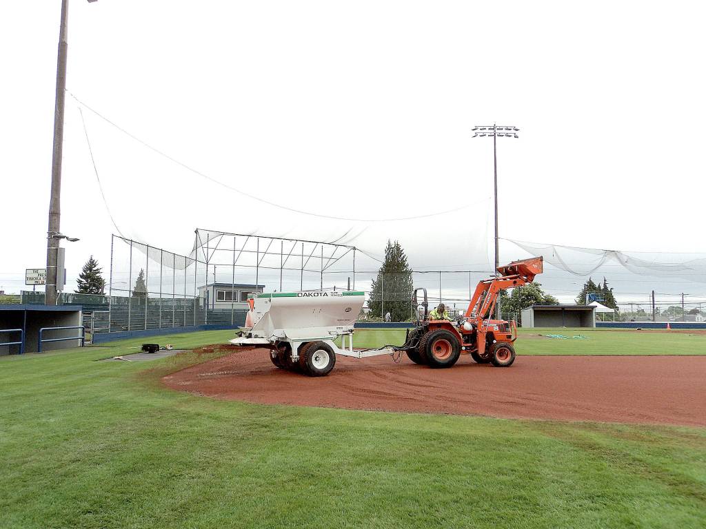 Pierre LaBossiere/Peninsula Daily News                                Darryl Anderson with the Port Angeles Parks and Rec Department lays down the infield clay at Civic Field Tuesday. The field and bleachers are all ready to go for the Lefties opener today.