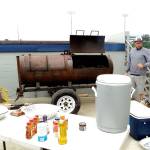 Pierre LaBossiere/Peninsula Daily News                                Mark Quinet prepares a smoker for the barbecue and food concession at Civic Field. Volunteers and staff tried out the smoker Wednesday, but Lefties fans get to check it out today.