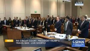 In this image made from a C-SPAN video, participants and members in the gallery stand as three judges for the 9th US Circuit Court of Appeals enter the room in Seattle on Monday. (CSPAN via AP, Pool)