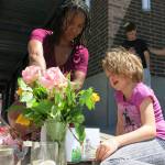 Angel Sauls, left, helps her stepdaughter, Coco Douglas, arrange a sign and some painted rocks she made for a memorial in Portland, Ore., on Saturday for two bystanders who were stabbed to death Friday while trying to stop a man who was yelling anti-Muslim slurs and acting aggressively toward two young women. (Gillian Flaccus/The Associated Press)