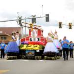 The 2017 Sequim Irrigation Festival royalty &mdash; Queen Karla Najera and Princesses Alison Cobb, Abby Norman and Emily Straling &mdash; and support staff wave to the crowd at the May 13 Grand Parade. (Michael Dashiell/Olympic Peninsula News Group)