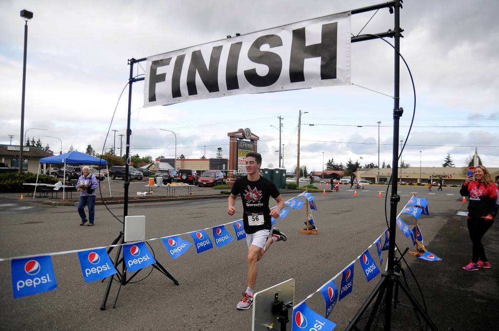 More than 70 participants broke from the starting line at Saturday&rsquo;s Sequim Irrigation Festival Fun Run 5K. Crossing the finish line in first place is Sequim teen Nate Despain. (Matthew Nash/Olympic Peninsula News Group)
