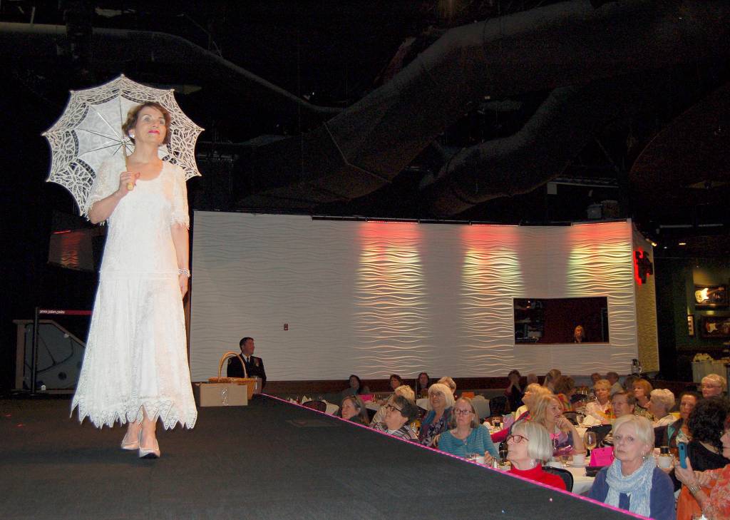 Rebecca Wallace models a lace dress with an umbrella during the Sequim-Dungeness Hospital Guild&rsquo;s annual luncheon and fashion show May 11 at 7 Cedars Casino in Blyn. (Erin Hawkins/Olympic Peninsula News Group)