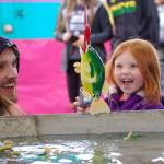 Three-year-old Annabel Lee of Bremerton celebrates a catch in the fish pond with her dad, Alexender Lee, at the Sequim Irrigation Festival&rsquo;s carnival on Saturday. (Matthew Nash/Olympic Peninsula News Group)