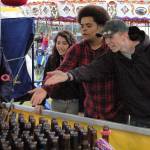 Sequim friends, from left, Anna Laurie, Trevor Jones and Payton Gagnon, all 18, enjoy a round of ring toss at the Sequim Irrigation Festival&rsquo;s carnival Saturday. It was Gagnon&rsquo;s first time at the carnival, he said, and they all had fun. (Matthew Nash/Olympic Peninsula News Group)