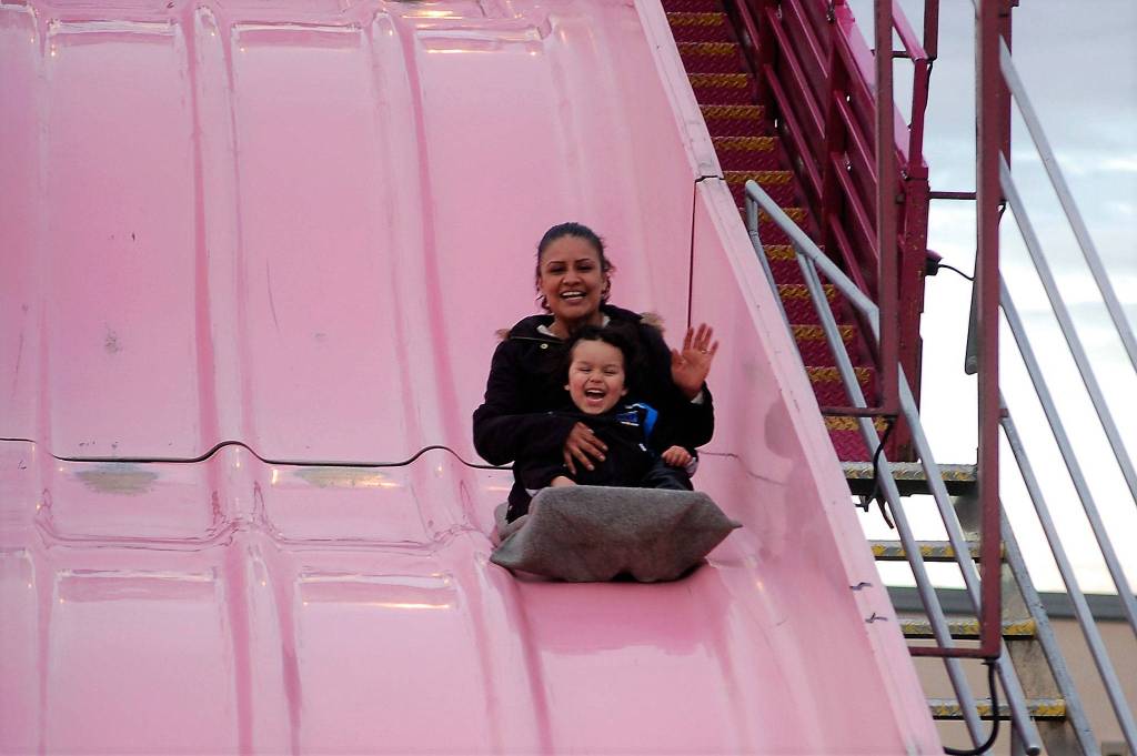 Grandma and grandson Juanita Taylor and Isaiah Loza, 3½, of Sequim, enjoy a quick ride down the Super Slide at the Sequim Irrigation Festival&rsquo;s carnival. Loza said it was their first time down the slide and it was exciting. (Matthew Nash/Olympic Peninsula News Group)