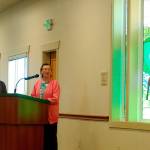 Millie Harrell, on right, created and donated the glass elk to the City of Sequim for its Guy Cole Convention Center remodel. She told a crowd May 16, including Sharon DelaBarre, chairman of the Sequim Arts Advisory Commission, on left, that she wanted it to stay in Sequim. (Matthew Nash/Olympic Peninsula News Group)
