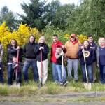 Homebuilders in the Mutual Self-Help Housing Program of the Peninsula Housing Authority pose at a ceremonial groundbreaking on West 15th Street in Port Angeles. From left are Justin Smith with Caidence and Caesyn Smith, Autumn Clark and Parker Silva, Alexis Biss, Linda Dolan, Robert Kalfur and Kayden Kalfur, Willy Feeney, Debbie and Jeremy Kirkland, and Karen and Jim Williams. (Dave Logan/for Peninsula Daily News)