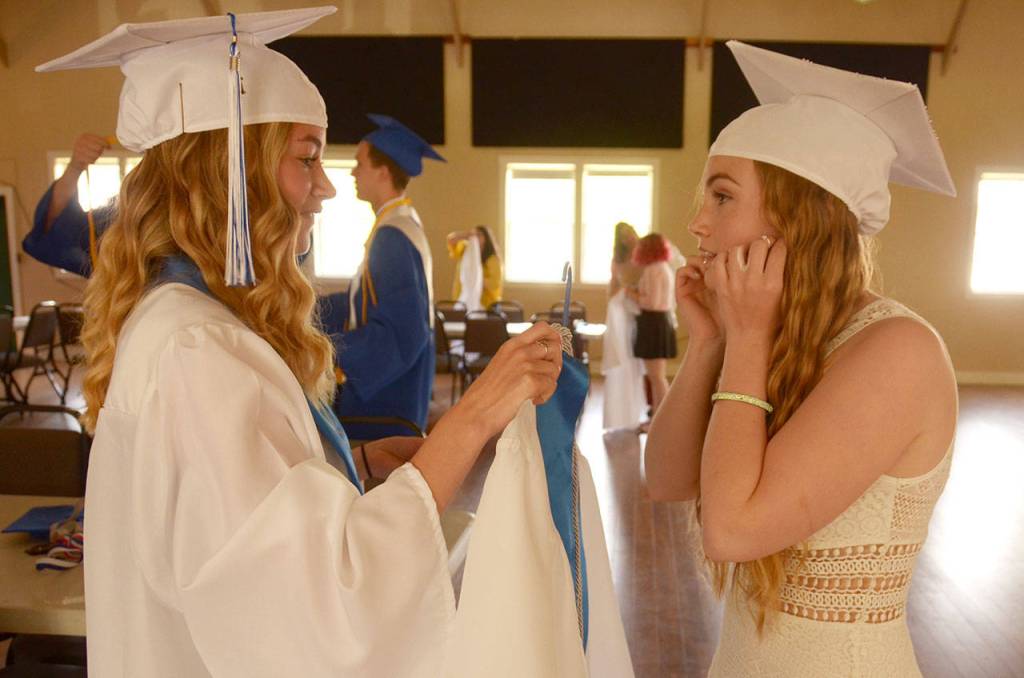 Chimacum seniors Rachel Smith and Jordyn Johnson get ready before their graduation ceremony Saturday in Port Townsend. (Cydney McFarland/Peninsula Daily News)