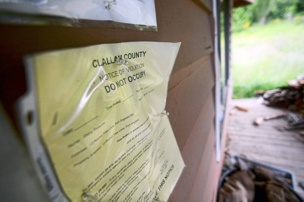 A &ldquo;do not occupy&rdquo; notice hangs on the wall of a vacant home. (Jesse Major/Peninsula Daily News)