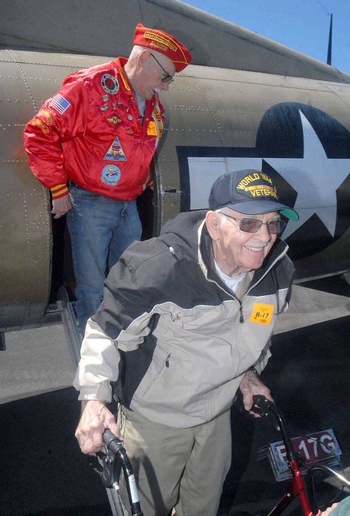 Veterans Don Alward, front, and Sid Gerling deboard a B-17 bomber after their flight with the Wings of Freedom Tour on Wednesday. (Keith Thorpe/Peninsula Daily News)
