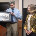 Clallam County Commissioner Mark Ozias, left, presents an etching of the county courthouse to retiring court admistrator Melinda Clevenger as a retirement gift during Tuesday&rsquo;s commissioners meeting. Clevenger&rsquo;s last day in the position is Friday, capping off a 43-year career with the Clallam County court system. (Keith Thorpe/Peninsula Daily News)