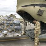 SSG Elizabeth Mosbach & SGT Tobias Amos, F Co. 2-135 General Support Aviation Battalion, U.S. Army Reserve, guide a pallet containing JISCC equipment onto a CH-47 Chinook in preparation for transport from Gray AAF to Port Angeles.