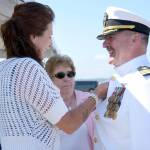 Rocky Pulley, the new commanding officer for Naval Magazine Indian Island, gets a pin placed on him by his wife, Bobbie Pulley, and mother, Cheri Pulley, during the change-of-command ceremony Thursday. (Cydney McFarland/Peninsula Daily News) ​